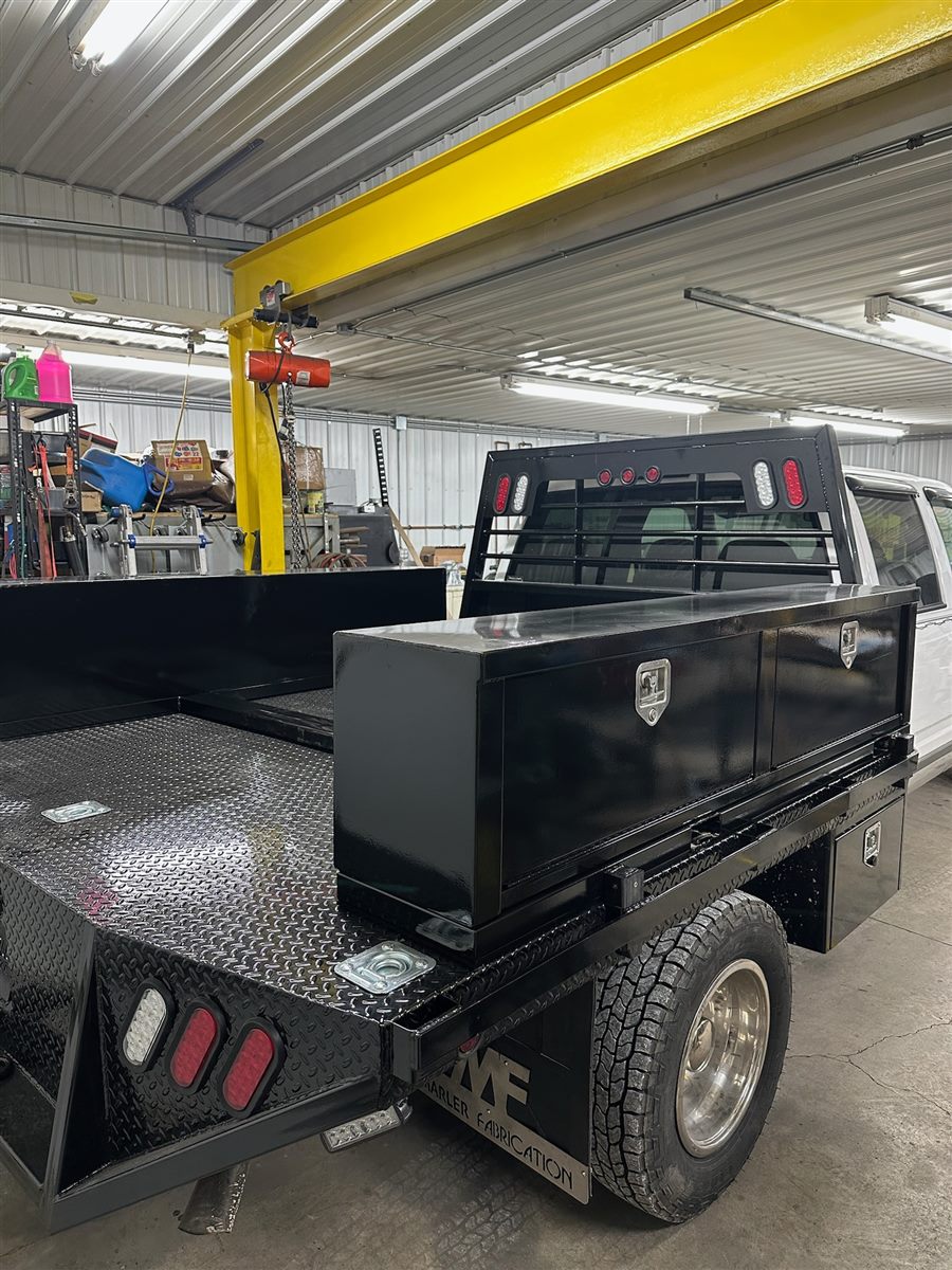 Custom black steel flatbed with top-mount toolboxes