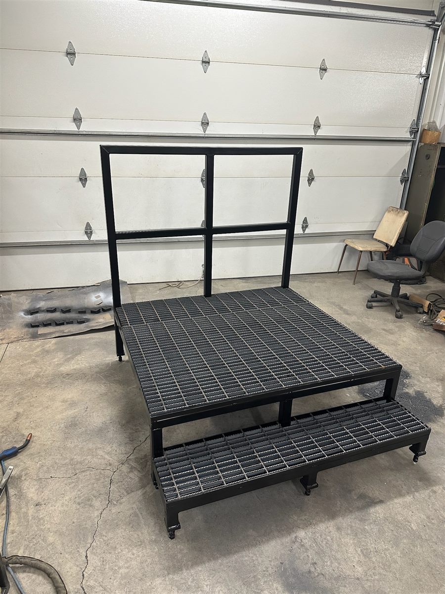 Smaller steel platform with a grating deck, a step and a back rail
