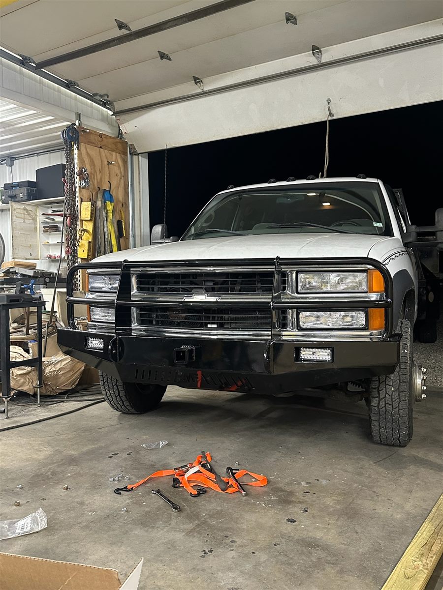 White Chevy pickup with a custom black steel front bumper and grille guard