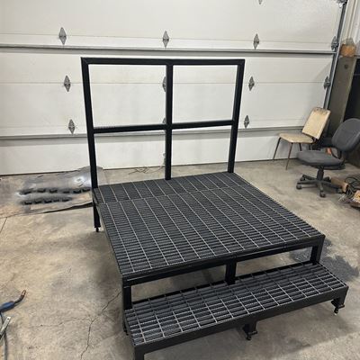 Smaller steel platform with a grating deck, a step and a back rail