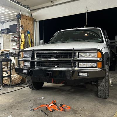 White Chevy pickup with a custom black steel front bumper and grille guard