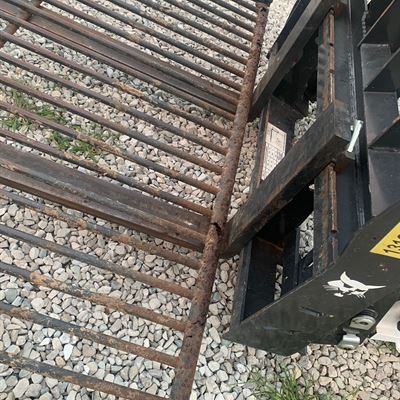 Steel grate on a skid steer attachment frame