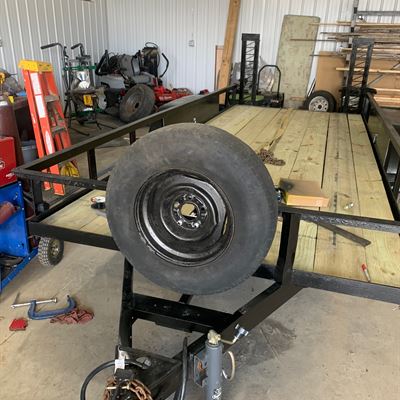 Trailer with a spare tire mount on the front rail