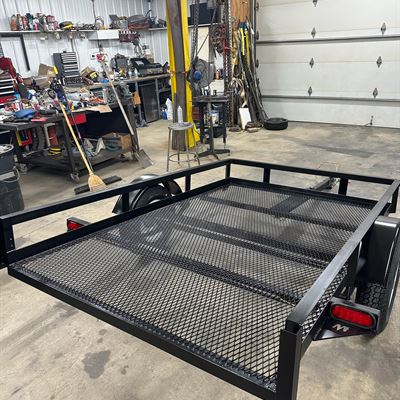 Small black utility trailer in the shop